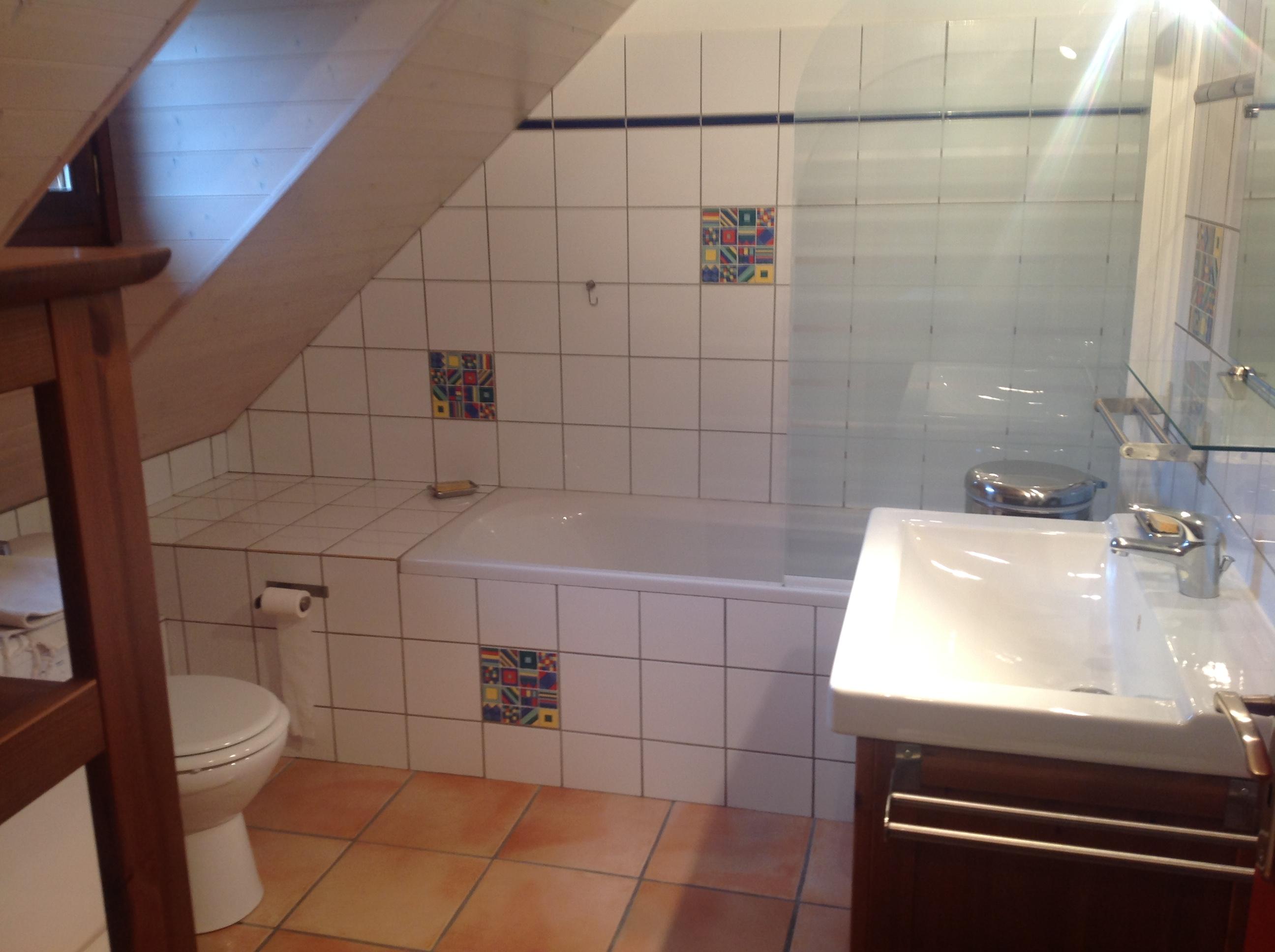Salle de bain située à l'étage avec 1 WC, 1 baignoire, lave linge et sèche linge
Le chalet dispose d'un 2ème WC en RDC