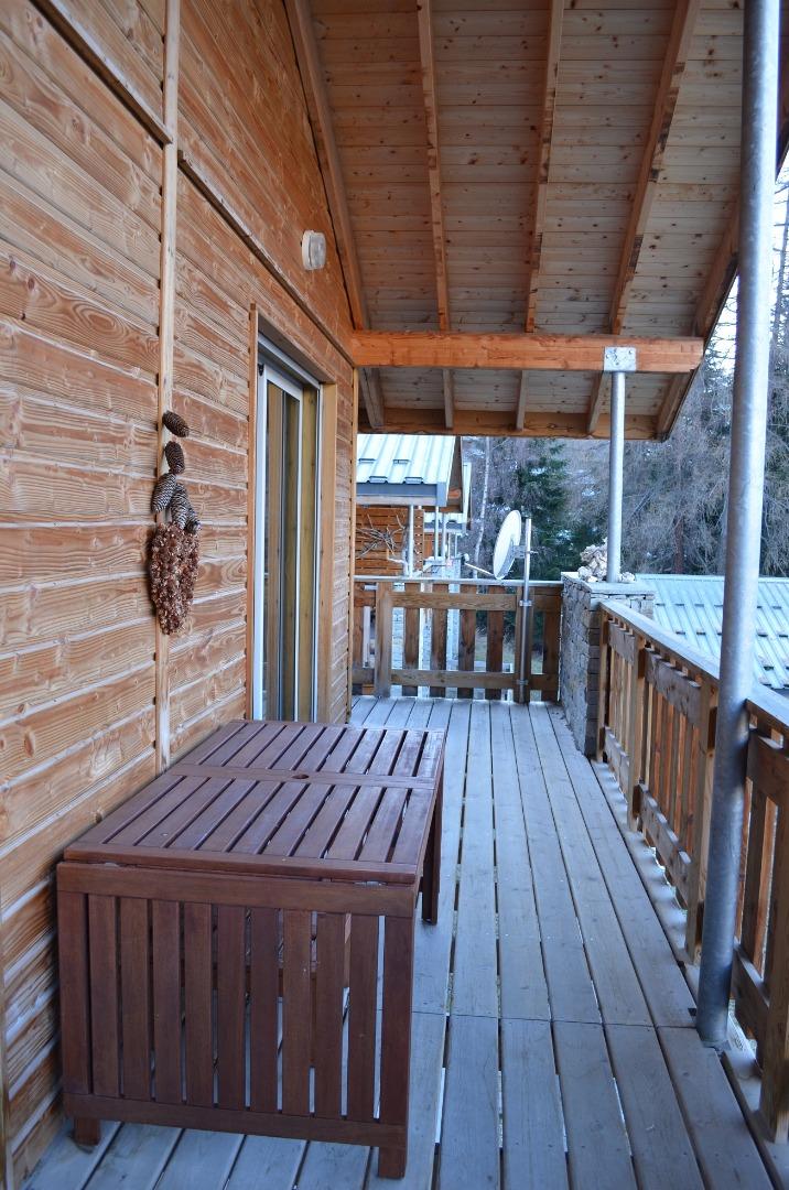 Terrasse attenante au salon avec mobilier d'extérieur.