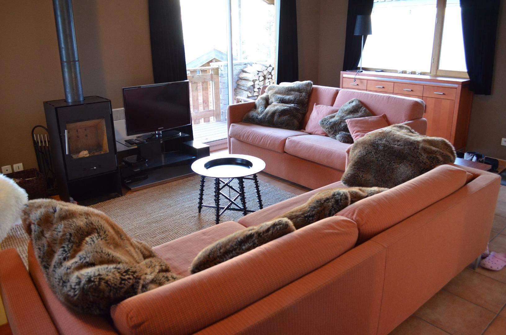 Coin salon avec télévision, poêle à bois, baie vitrée, convertible en 160x200.