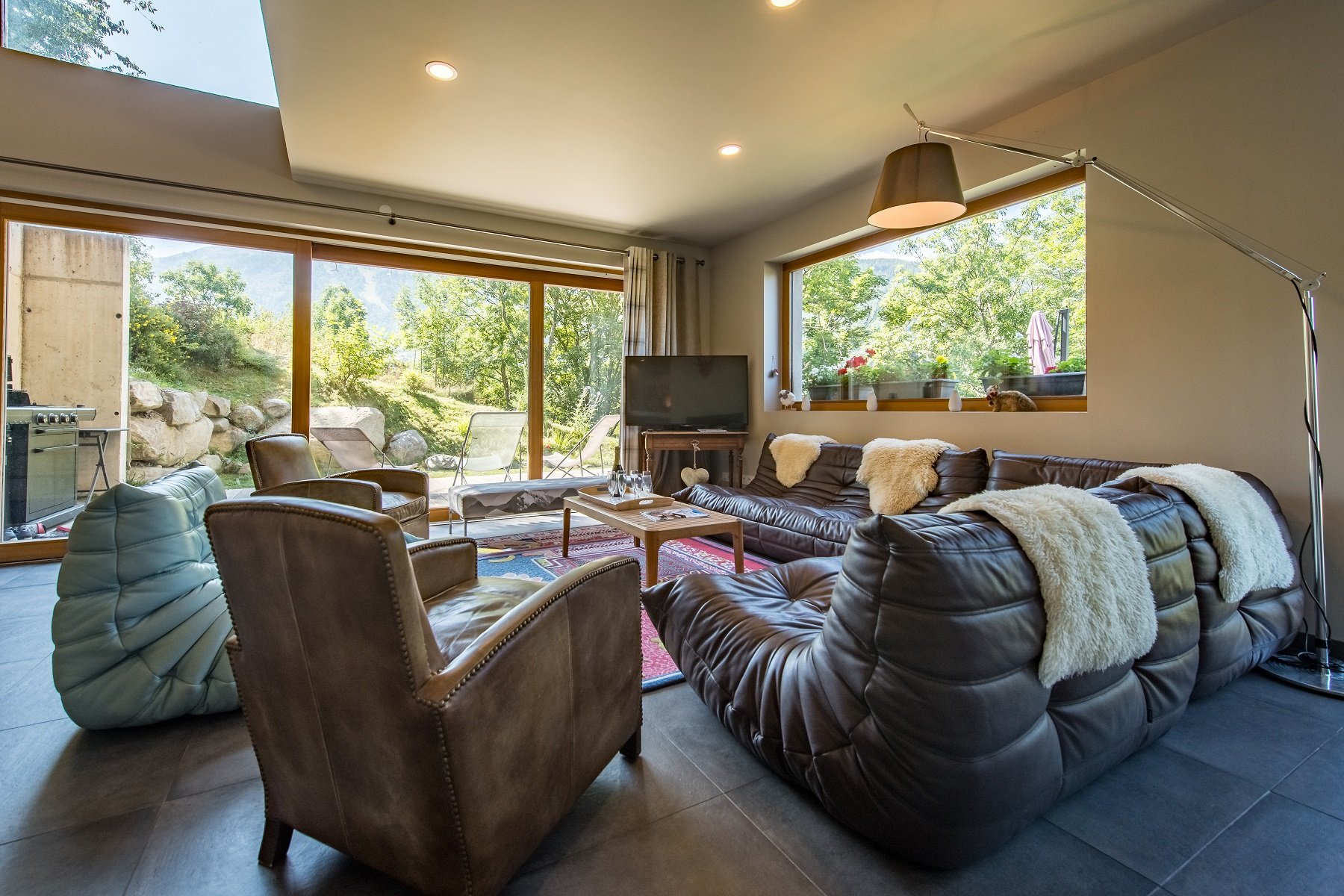 Le salon avec ses grandes baies vitrées et accès direct à la terrasse et au jardin.