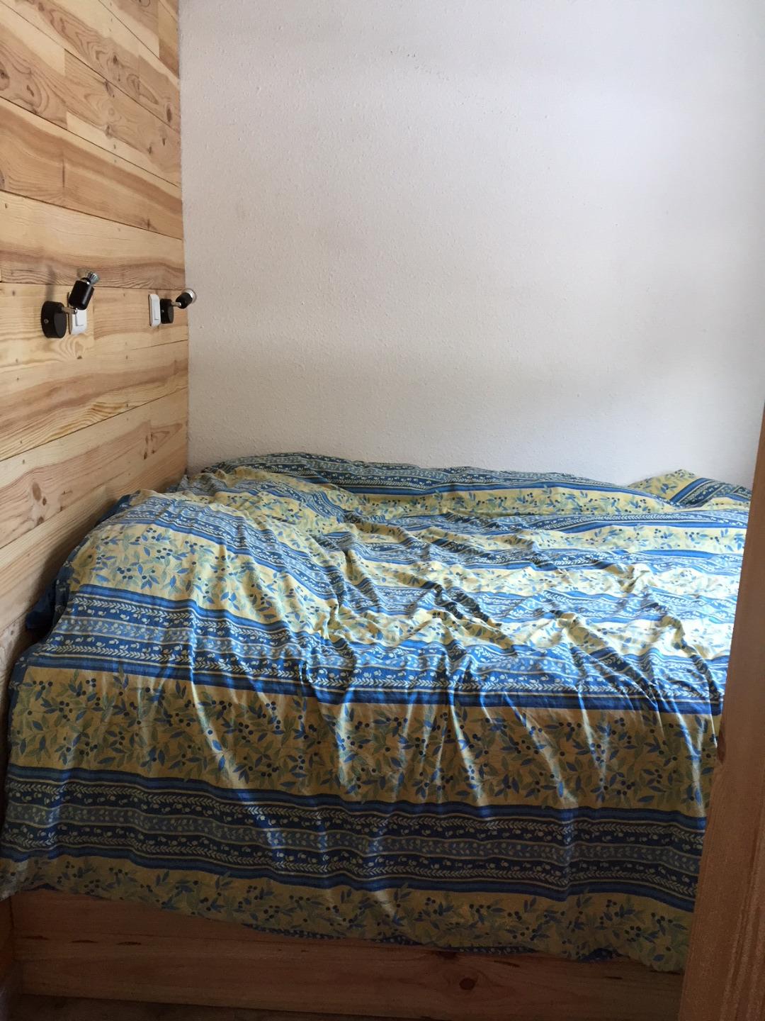 Le lit en 140 dans la chambre. Il est monté sur vérin, ainsi vous accédez facilement à un espace de rangement pour les valises sous le lit