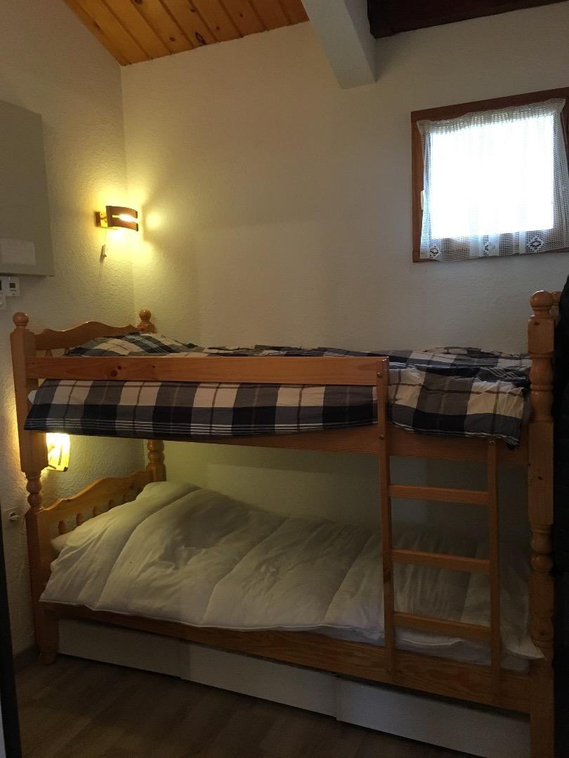 Dans l'entrée, séparée du séjour par une porte, un lit superposé avec 3 coffres de rangements de vêtements