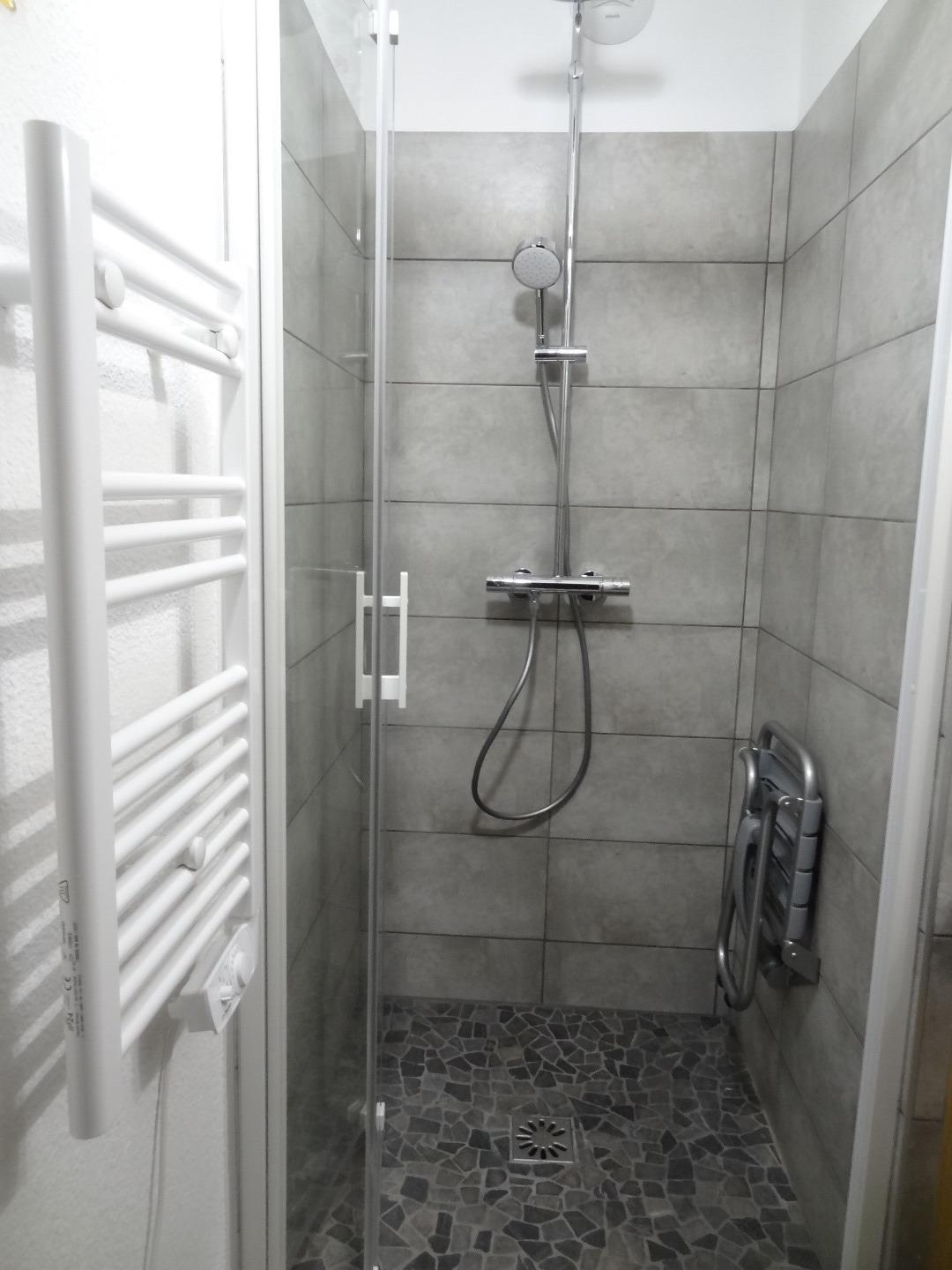 La douche à l'italienne de 90*90, lavabo et radiateur sèche serviettes