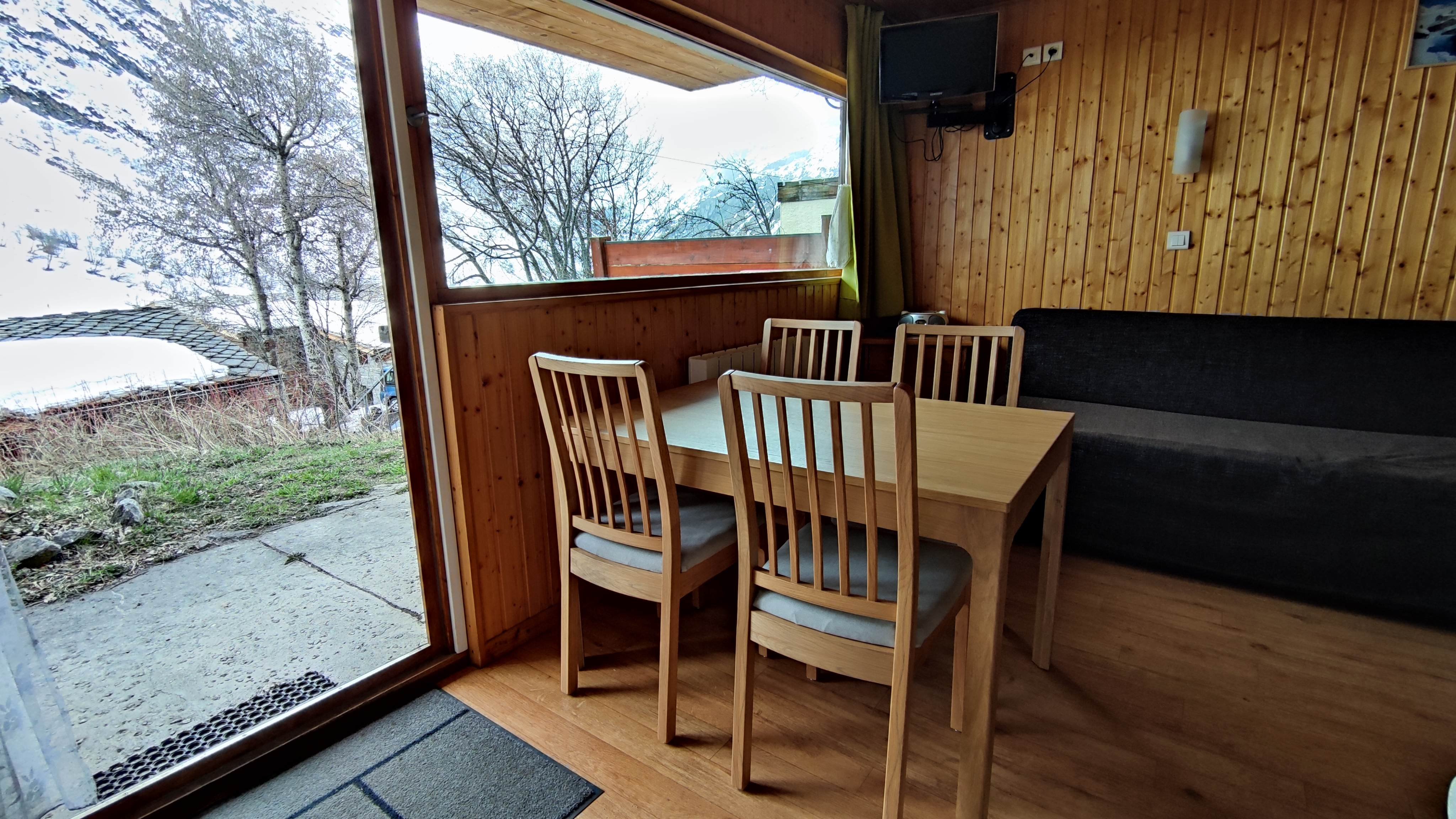 Coin repas, téléviseur, banquette.