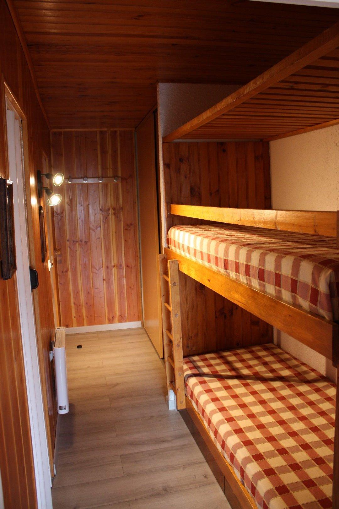 Couloir avec lits superposés et rambarde de protection à l'étage supérieur
Au fond à Droite placards et à Gauche, entrée salle de bain