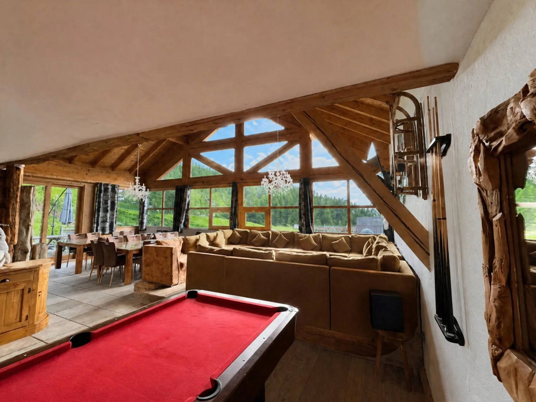 Grand canapé d'angle en U sous un toit cathédrale de 5m de hauteur, billard et salle à manger pour 22 personnes