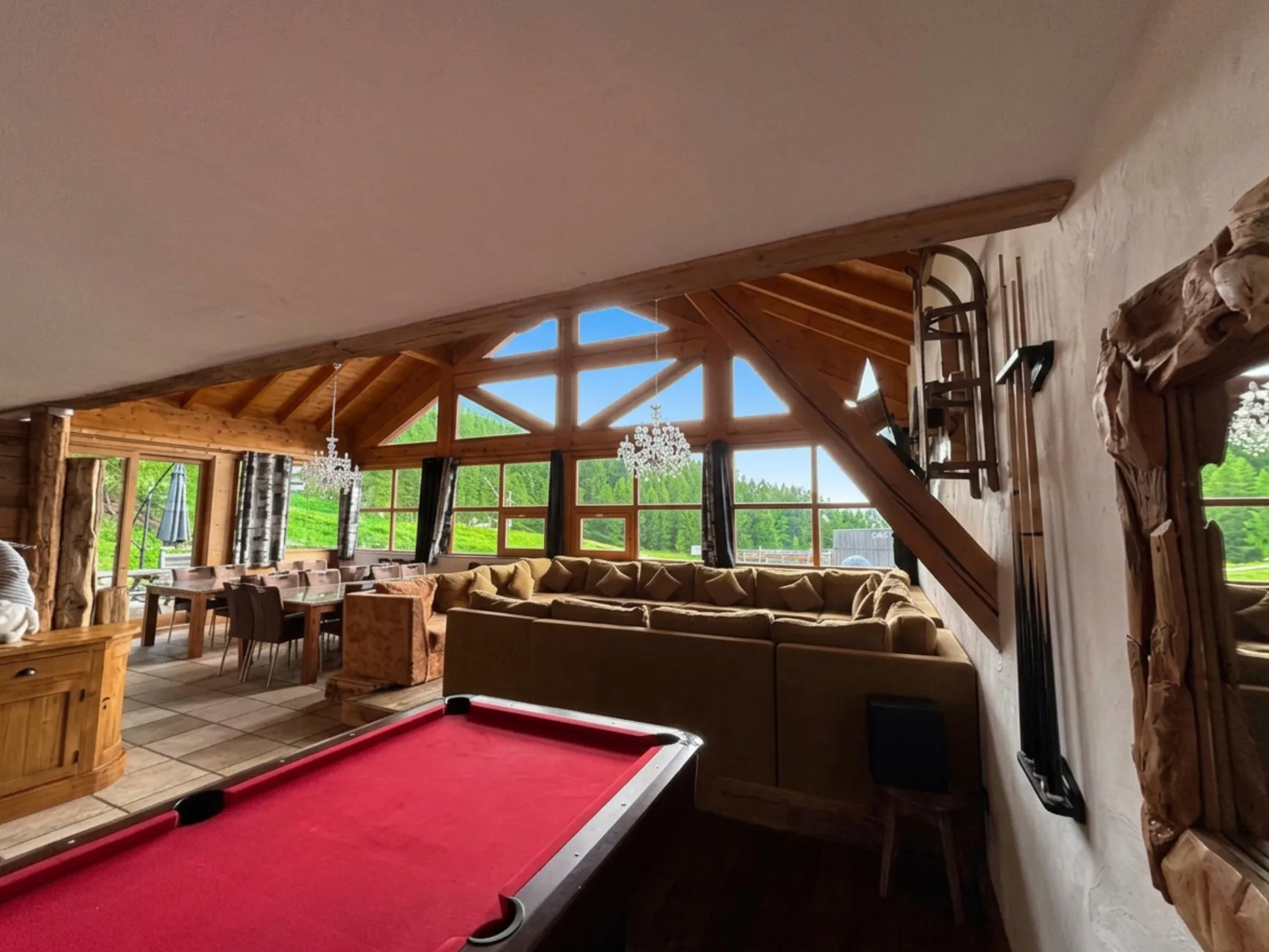 Grand canapé d'angle en U sous un toit cathédrale de 5m de hauteur, billard et salle à manger pour 22 personnes
