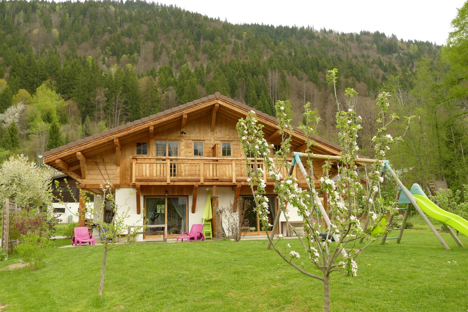 Le chalet vue de devant, en arrière plan la forêt où se c accent de nombreux animaux sauvages (chevreuils, cerfs, renards)