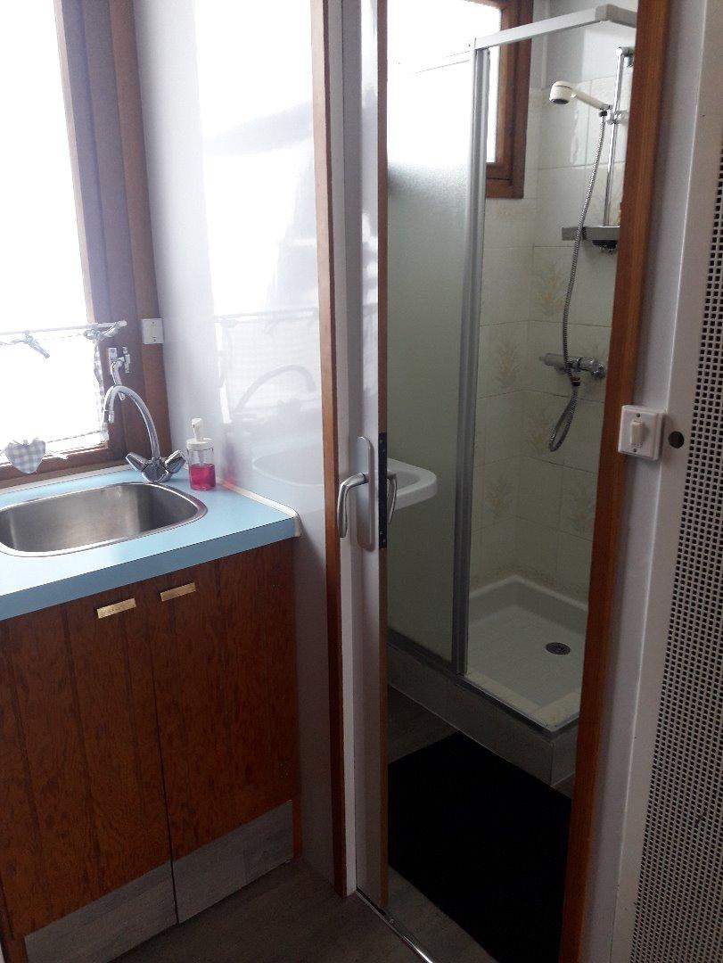 Salle d'eau avec cabine de douche, lavabo, sèche serviette, meuble colonne et toilette