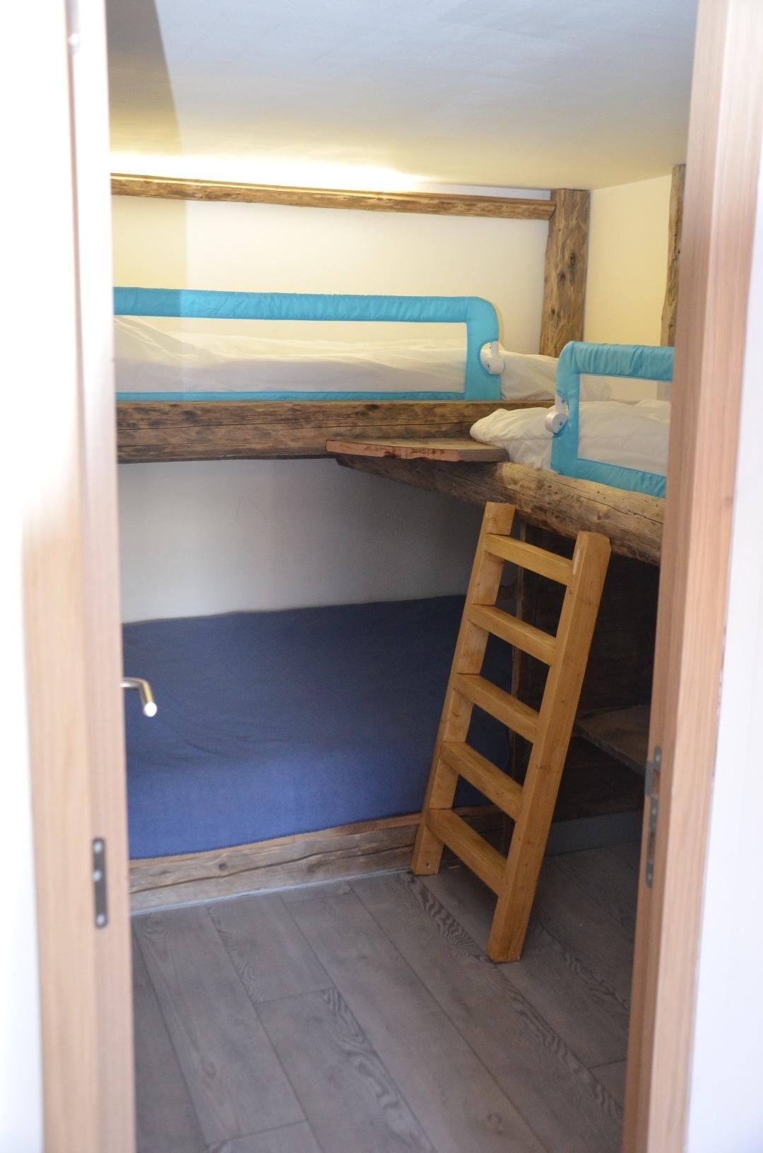 La chambre compte un lit double/un lit simple superposé ainsi qu'un deuxième lit simple elevé.
La fenêtre donne sur la vallée de la tarentaise.
