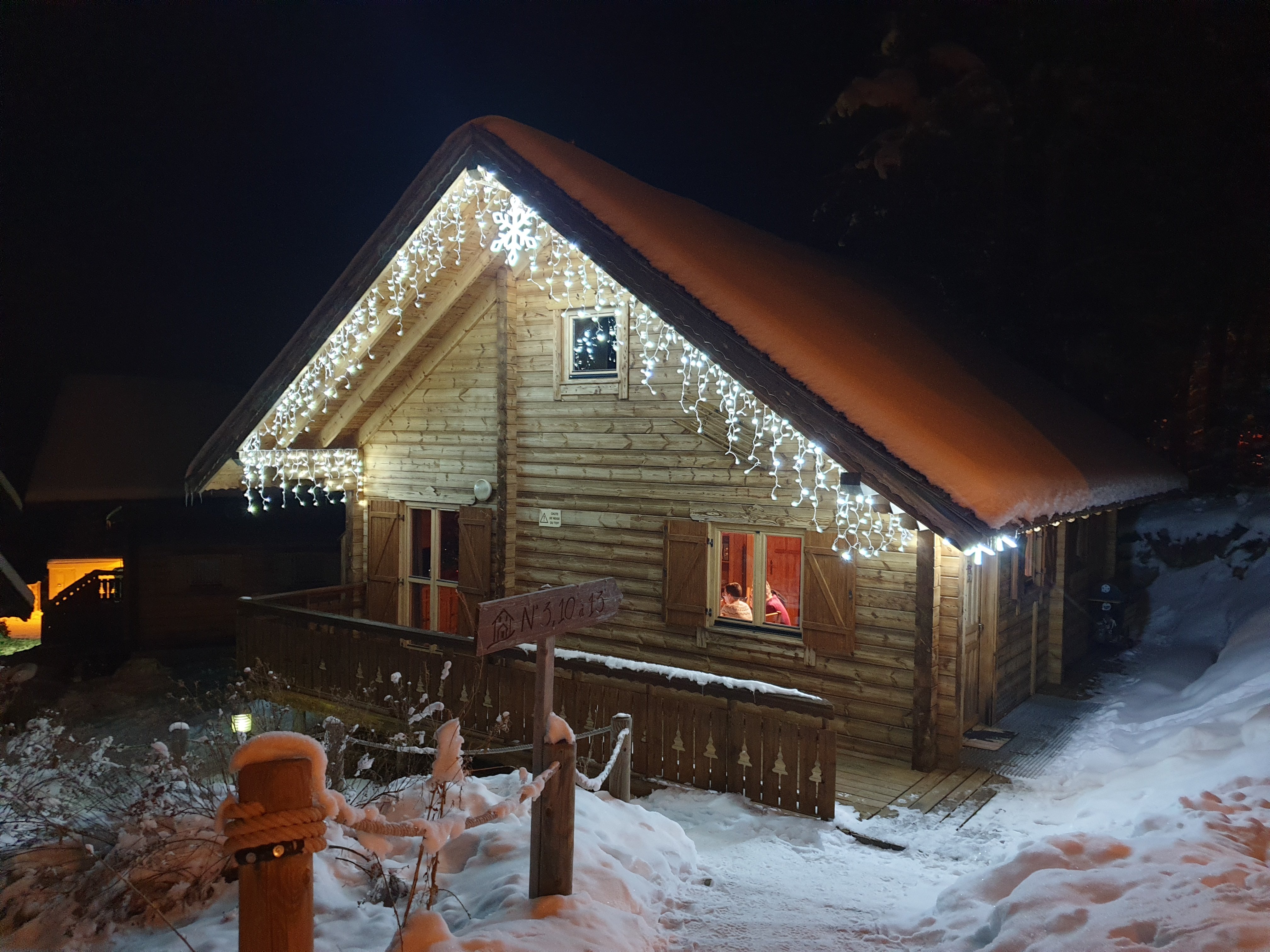 Le chalet illuminé sous la neige