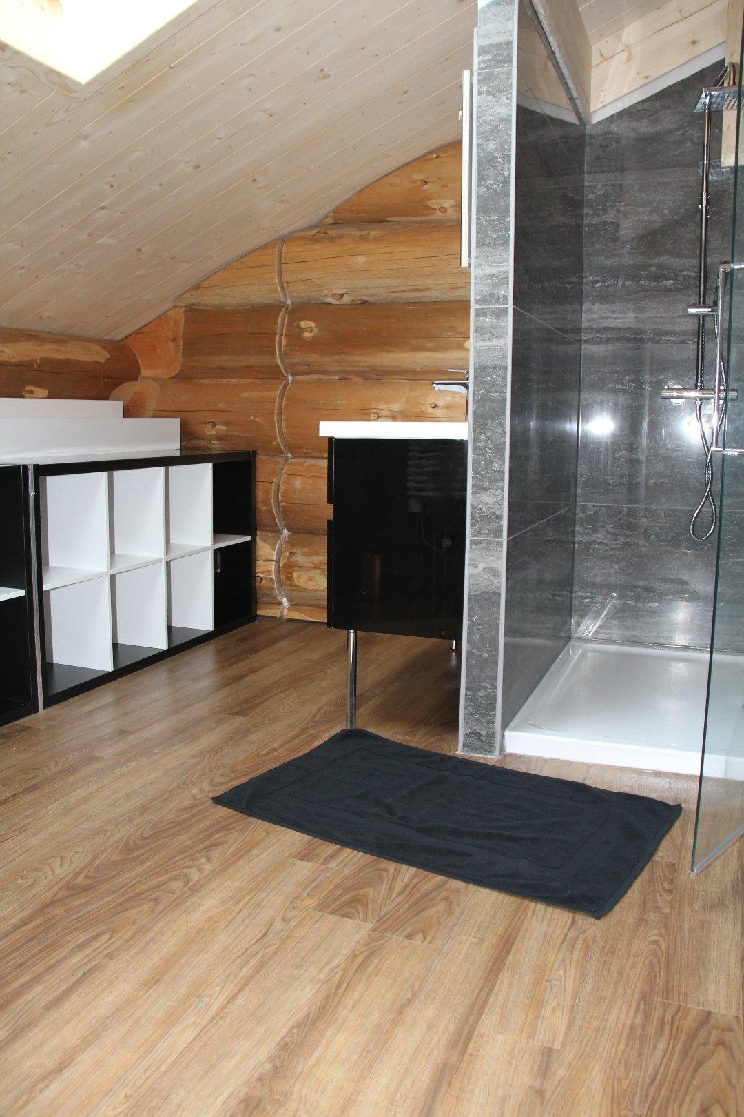 sale de bais avec sèche serviette et une douche de 90 x 120  un grand lavabos et divers rangement 