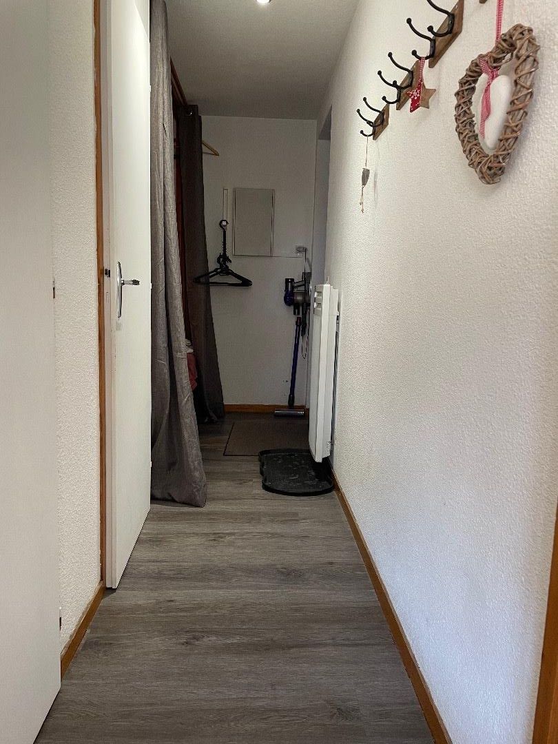 Petit couloir desservant les wc la salle de douche le coin nuit et la porte d’entrée 