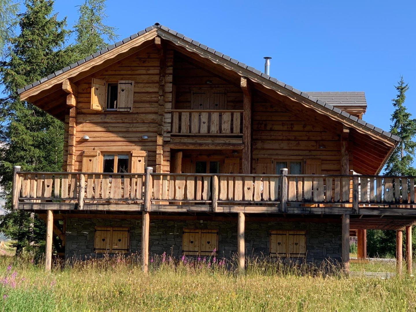 Un grand terrain se situe devant le chalet donnant une vue dégagée sur les différents massifs 