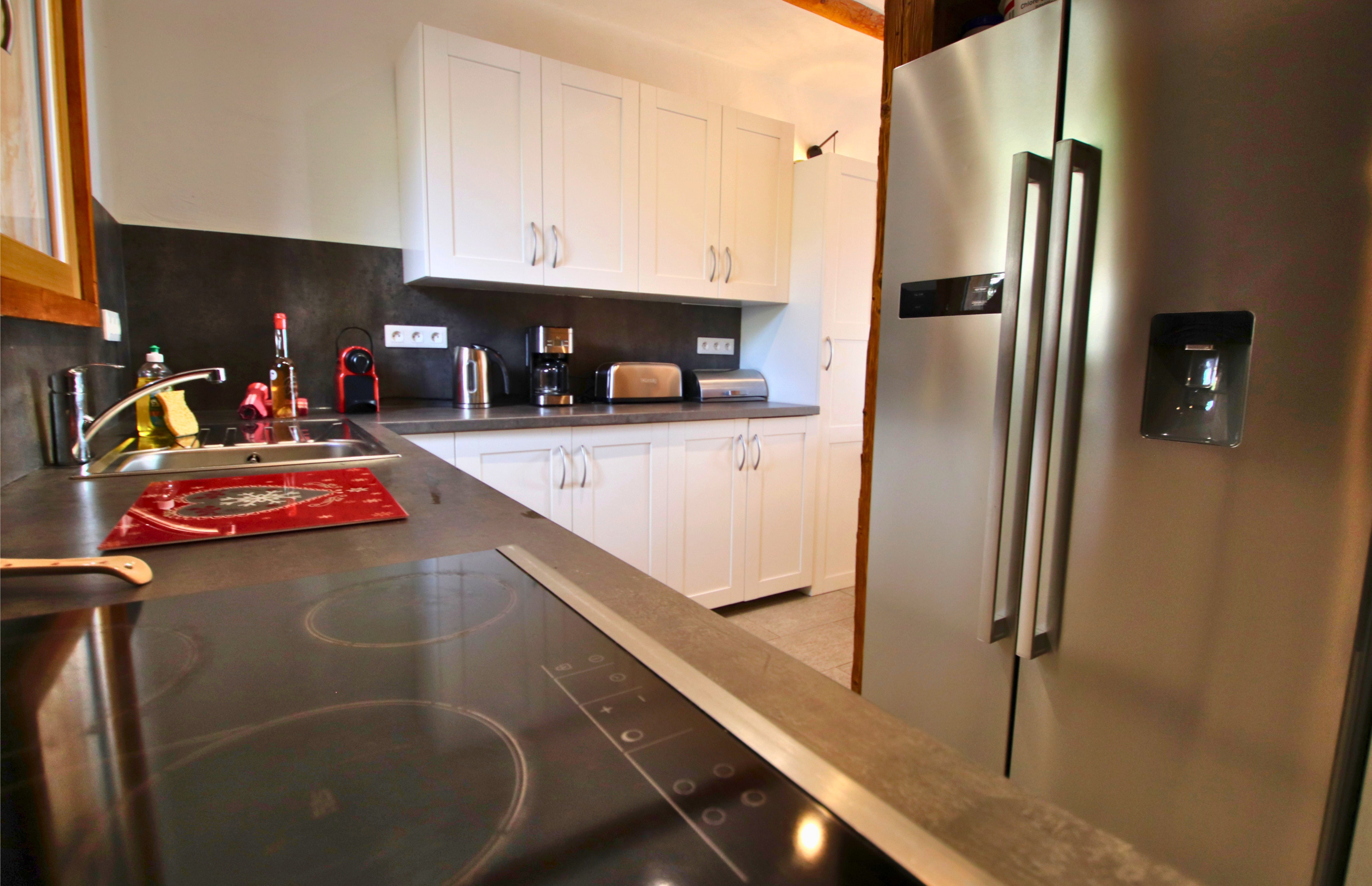Une cuisine ouverte ultra-moderne, dotée de plaques de cuisson performantes et d'un grand frigo américain pour accueillir vos tribus.