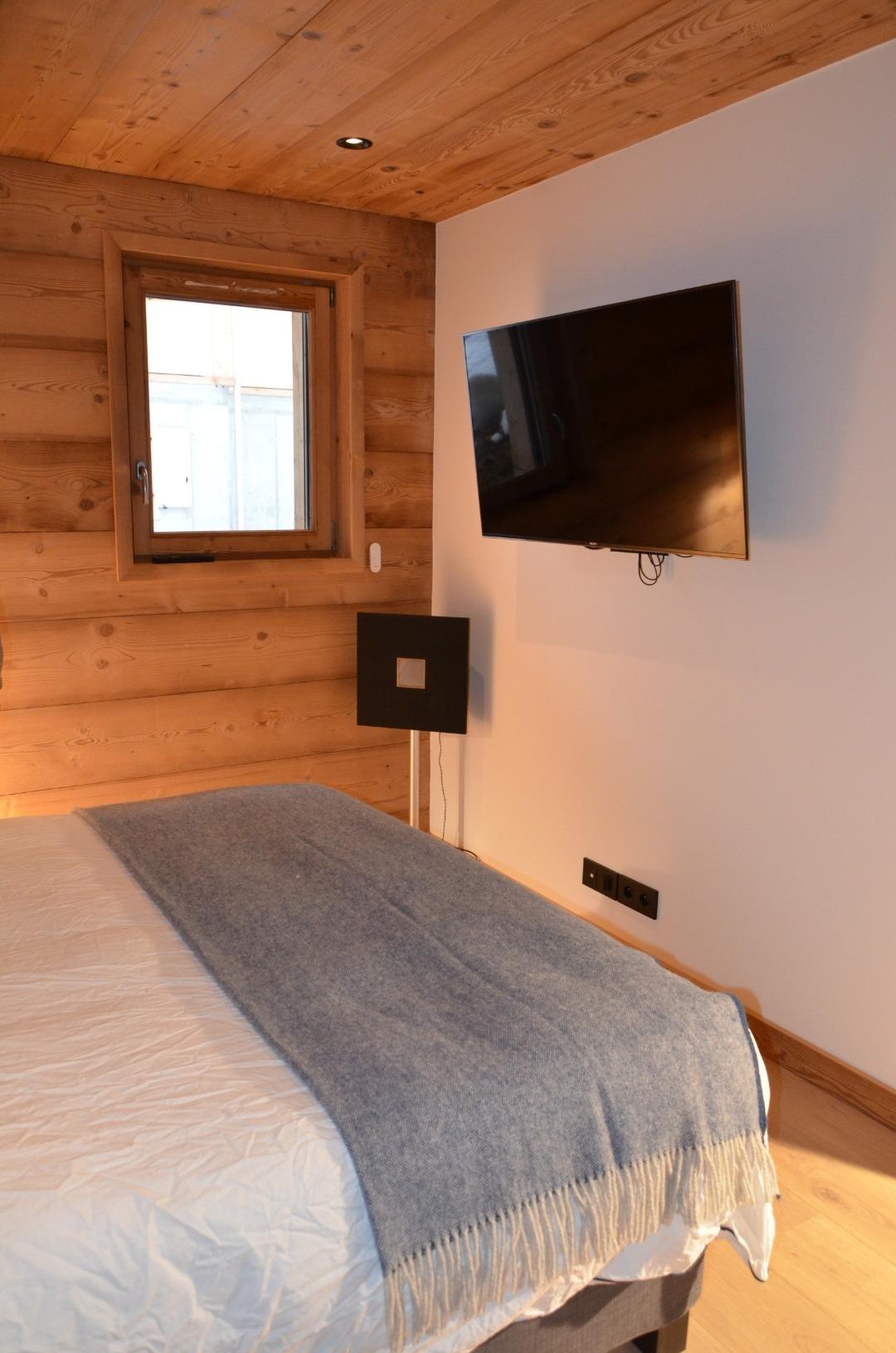 TV murale dans la chambre parentale