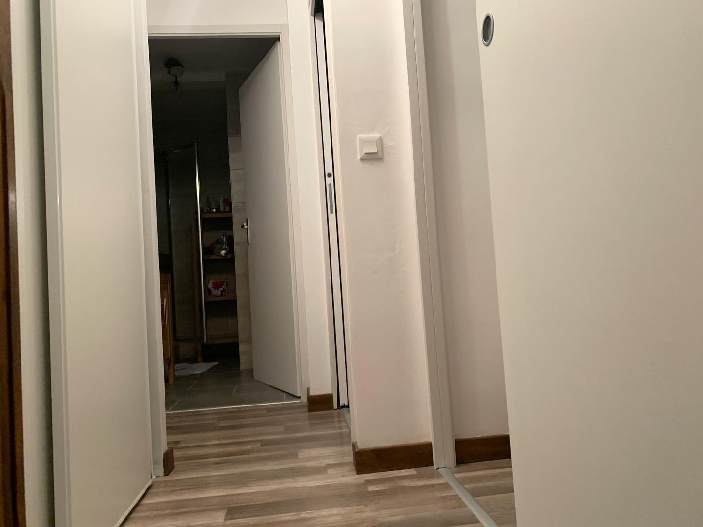 Couloir étage avec de nombreux placards de rangement desservant les deux chambres, la salle de douche et les wc indépendant