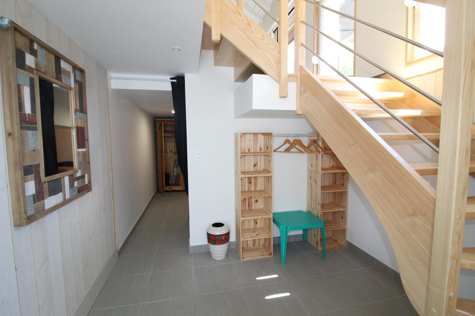 entrée spacieuse et lumineuse,avec escalier 1/4 tournant pour l'étage, au fond  
derriere le rideau noir  chambre avec 2 lits 1p et 1 armoire 